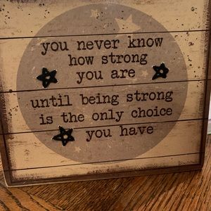 Inspirational saying on wood sign with woven stars and stars in the wood.